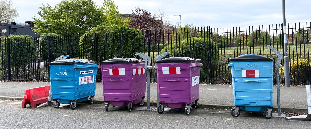 Shared household recycling and general waste bins on a residential street in Liverpool